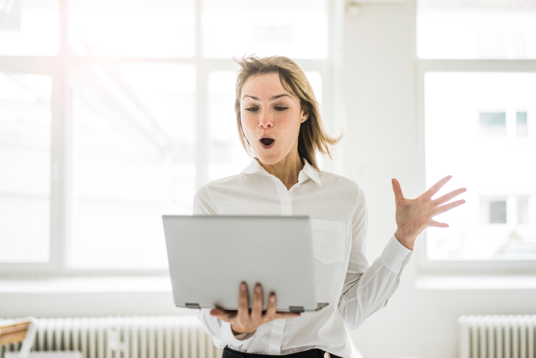 Lady standing up holding laptop