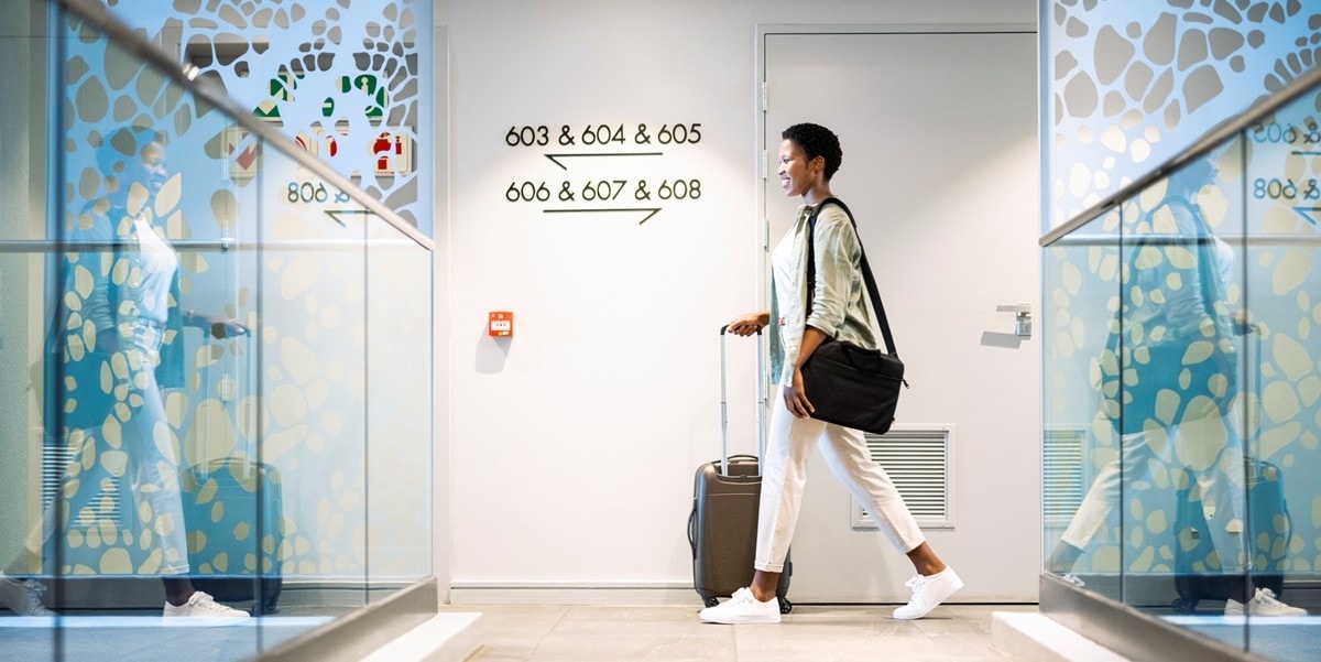 Woman walking through building with luggage