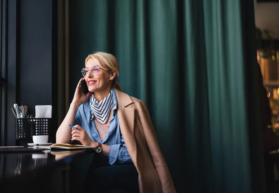 business woman in cafe speaking on the phone 