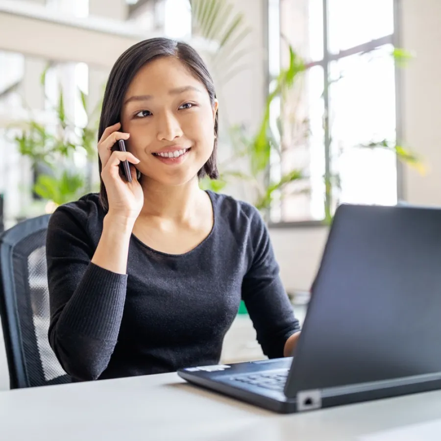 Lady on phone looking at laptop